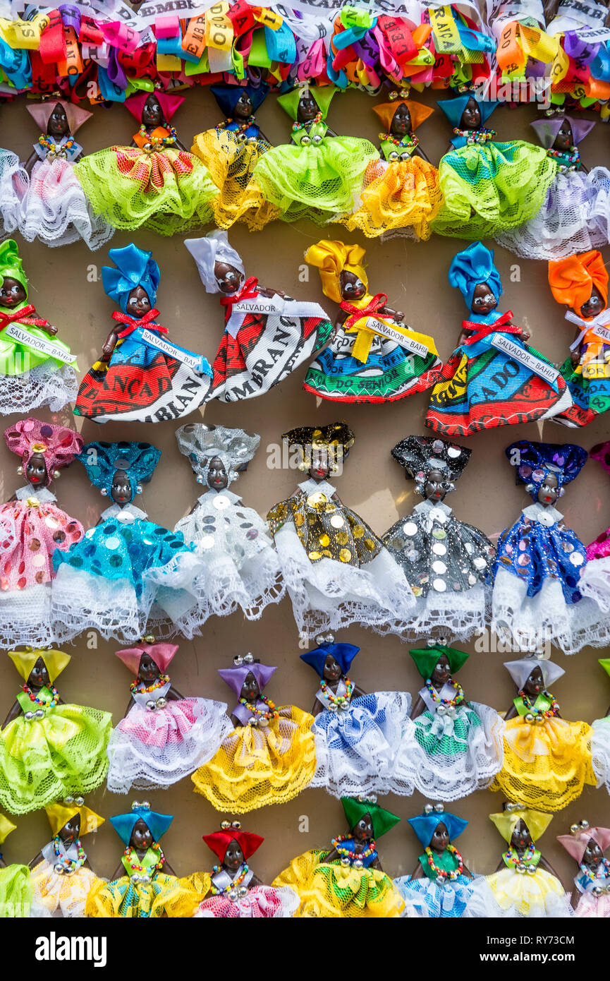 Statuetta di Souvenir magneti con buona fortuna brasiliano nastri desiderano decorare il tradizionale costume abiti delle figurine in miniatura in Salvador Brasile Foto Stock