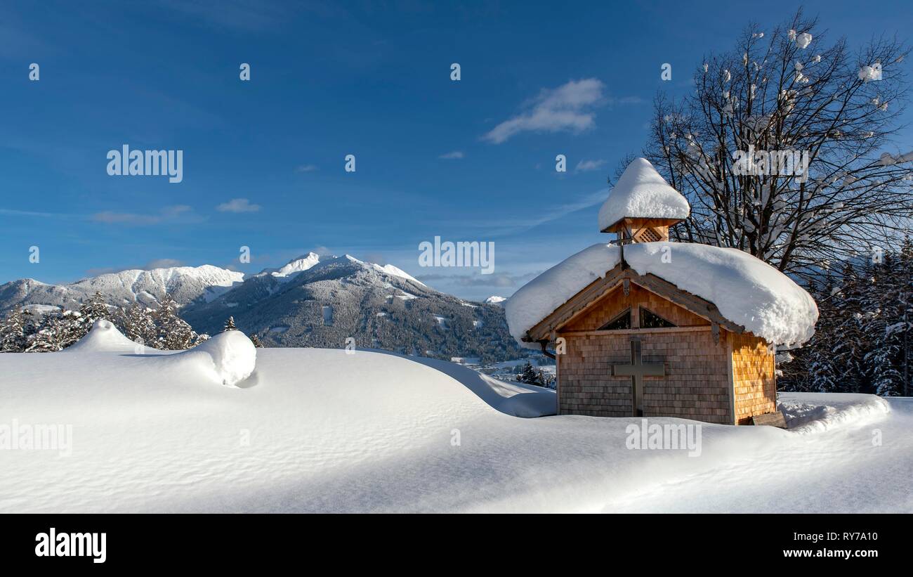 Cappella di legno con neve sul Vomperberg, Kellerjoch sul retro, Tirolo, Austria Foto Stock