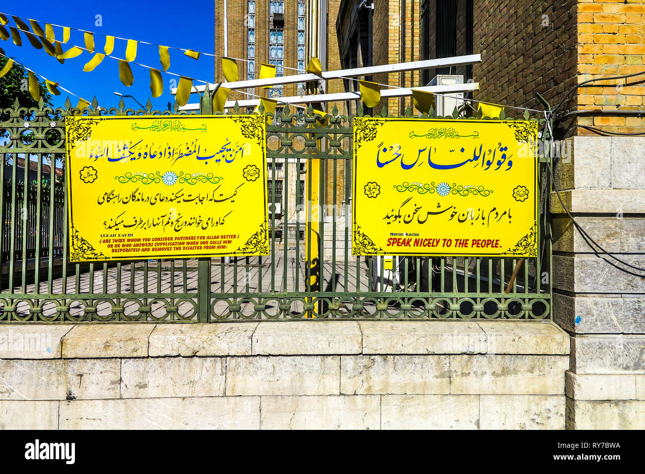Tehran Corano citazioni su un giallo scheda colorata e la recinzione Foto Stock