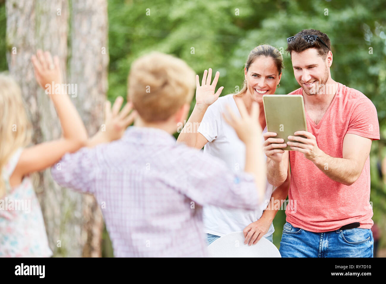 Genitori felici di scattare una foto dei loro figli in natura in vacanza Foto Stock