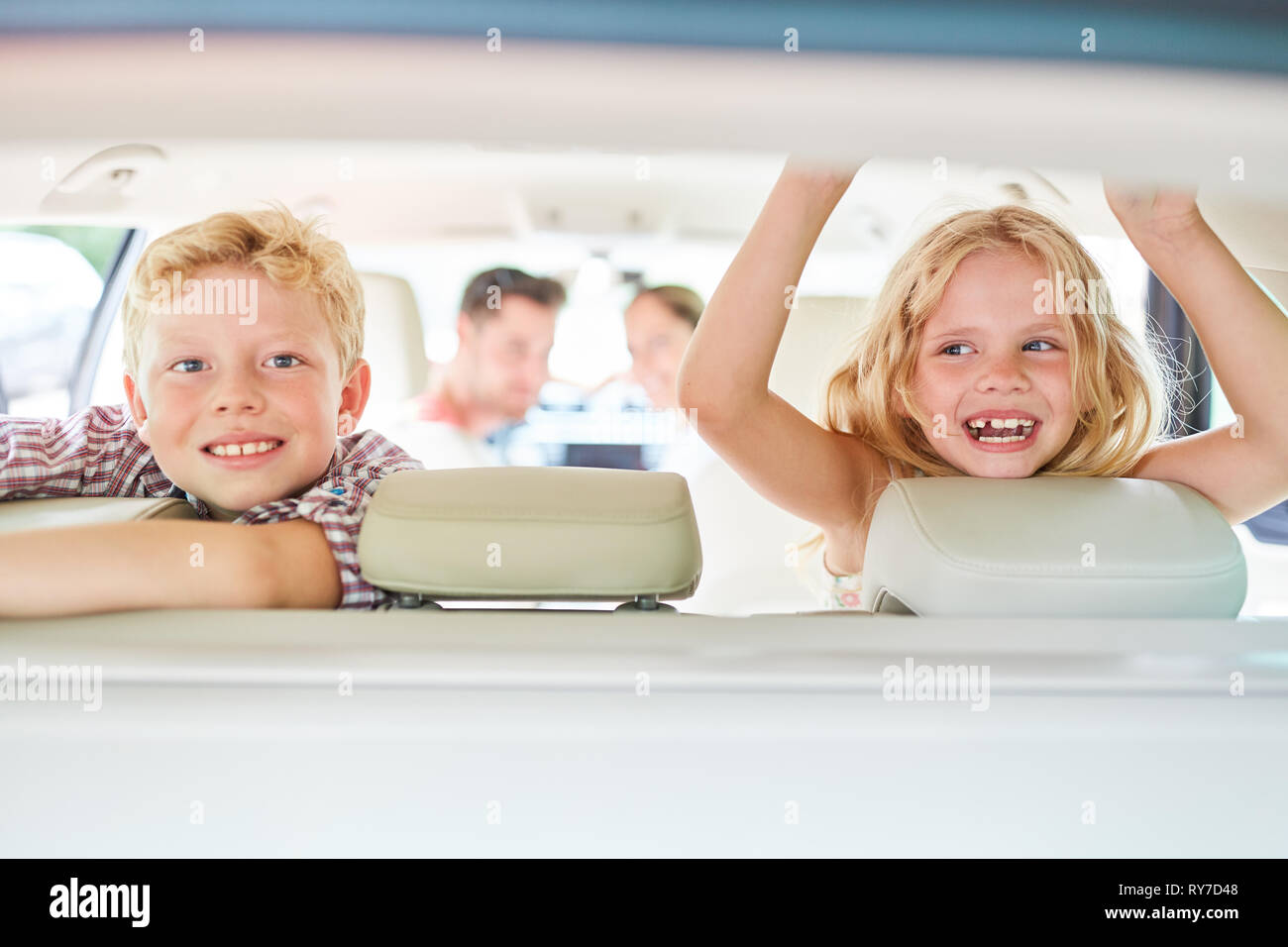 Due bambini nel sedile posteriore in auto in vacanza con la mia famiglia Foto Stock