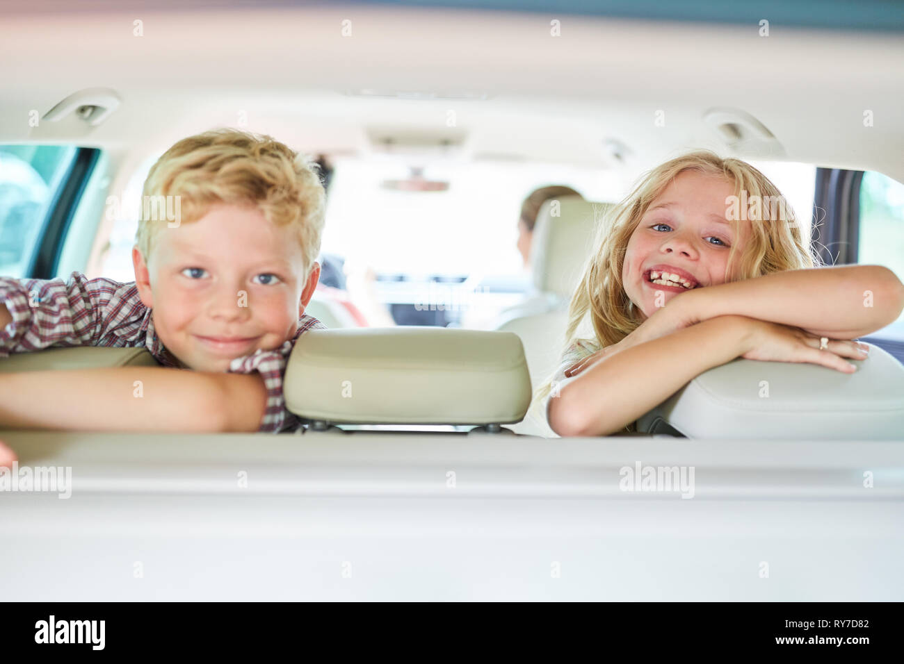 Due bambini nel sedile posteriore in auto sono impaziente di vacanze estive Foto Stock