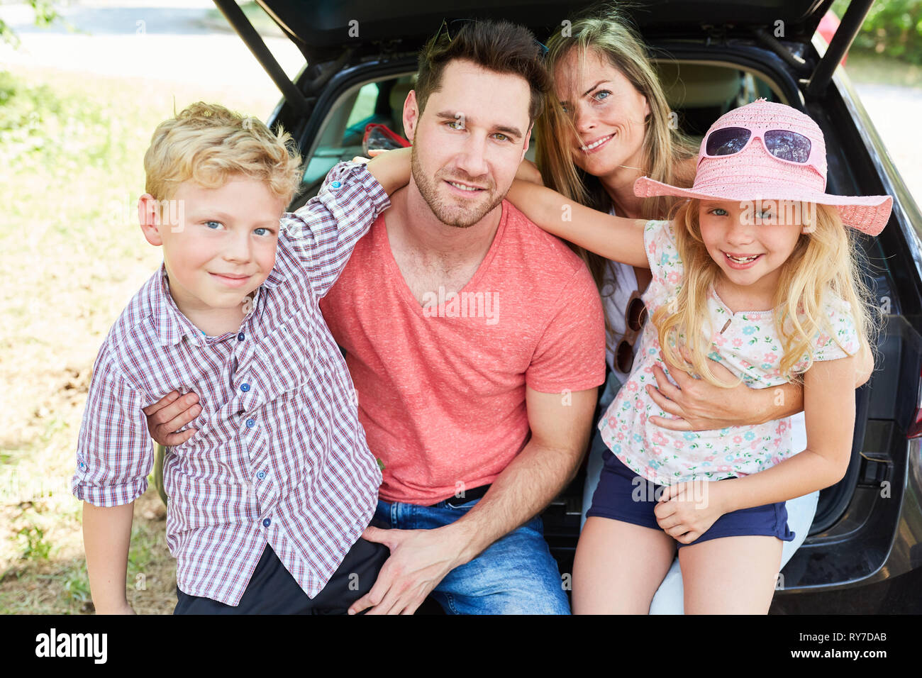 Famiglia con due bambini in auto in vacanza in estate Foto Stock