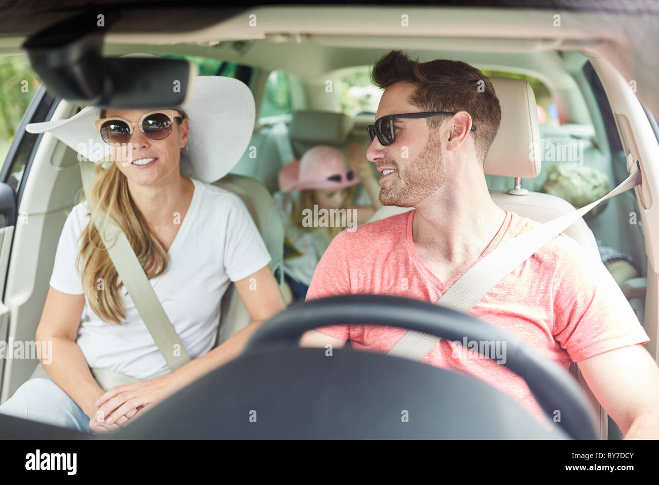 Felice famiglia con due bambini in auto sulla strada per le vacanze estive Foto Stock