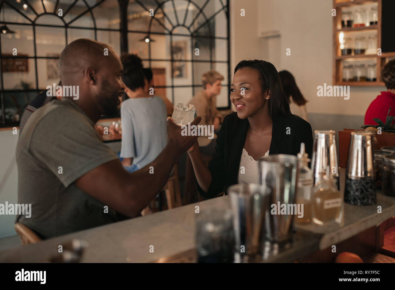 Giovane americano africano giovane bevendo un drink in un bar Foto Stock