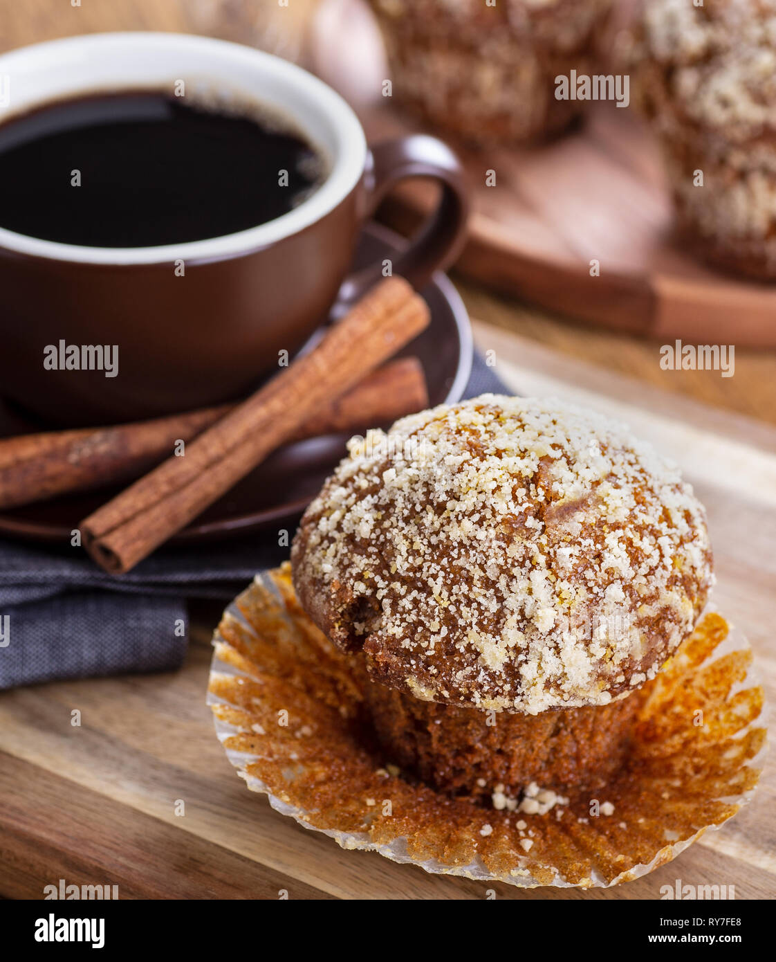 Primo piano di un muffin di zucca con una tazza di caffè e muffin in background Foto Stock