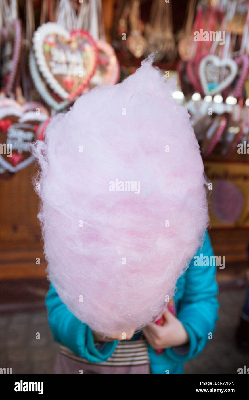 Bambino tenere grandi rosa Candy Floss davanti al suo volto ad un mercatino di Natale Foto Stock