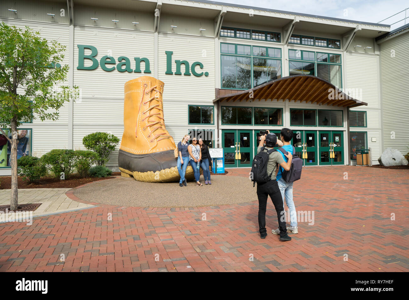 I visitatori di prendere una foto ricordo con il novantesimo anniversario bean boot nella parte anteriore del LL Bean store in Freeport, Maine, Stati Uniti d'America. Foto Stock