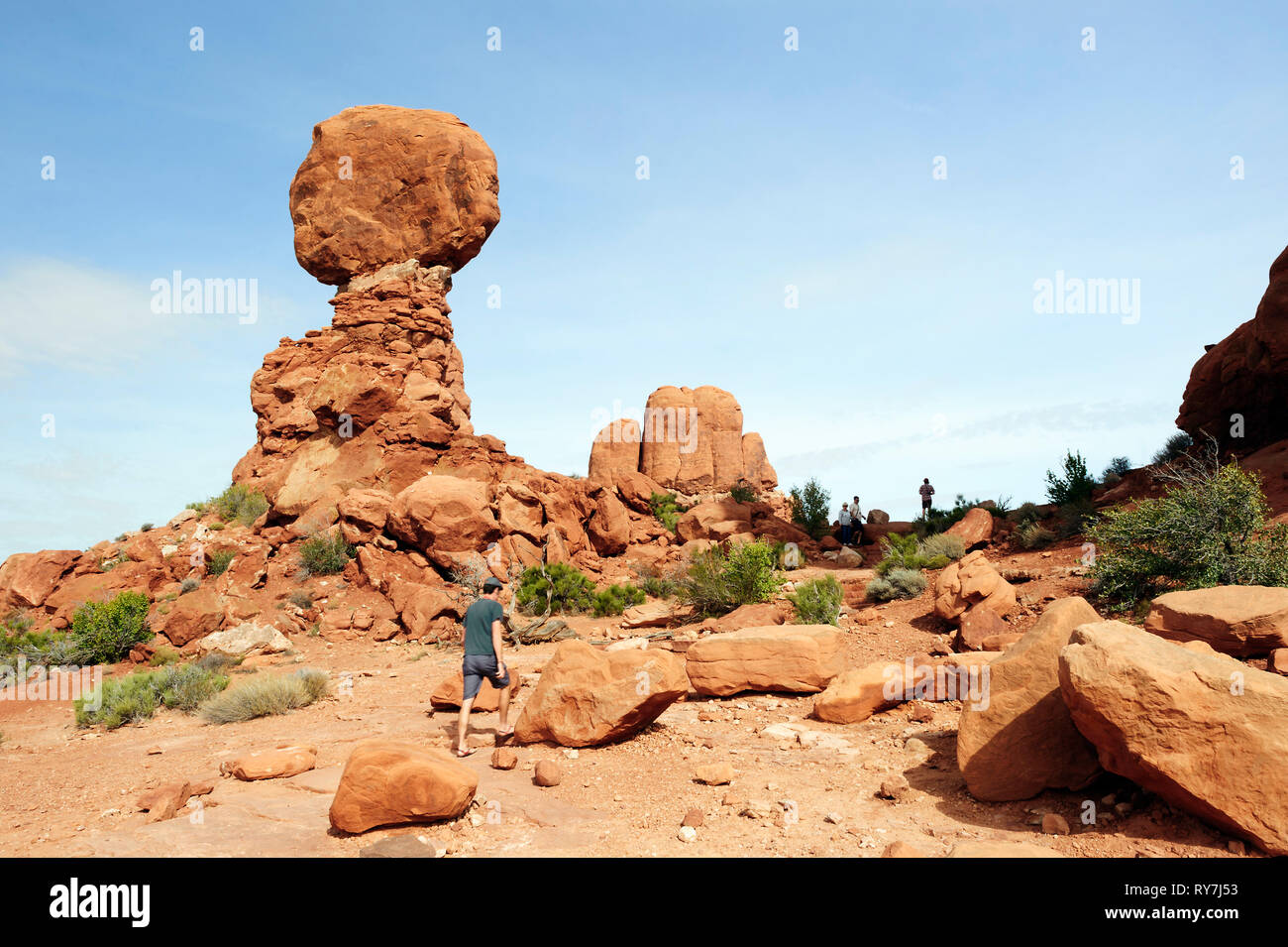 Visitatore passeggiate da un equilibrato Rock, una famosa formazione rocciosa Arches National Park nello Utah, Stati Uniti d'America. Foto Stock