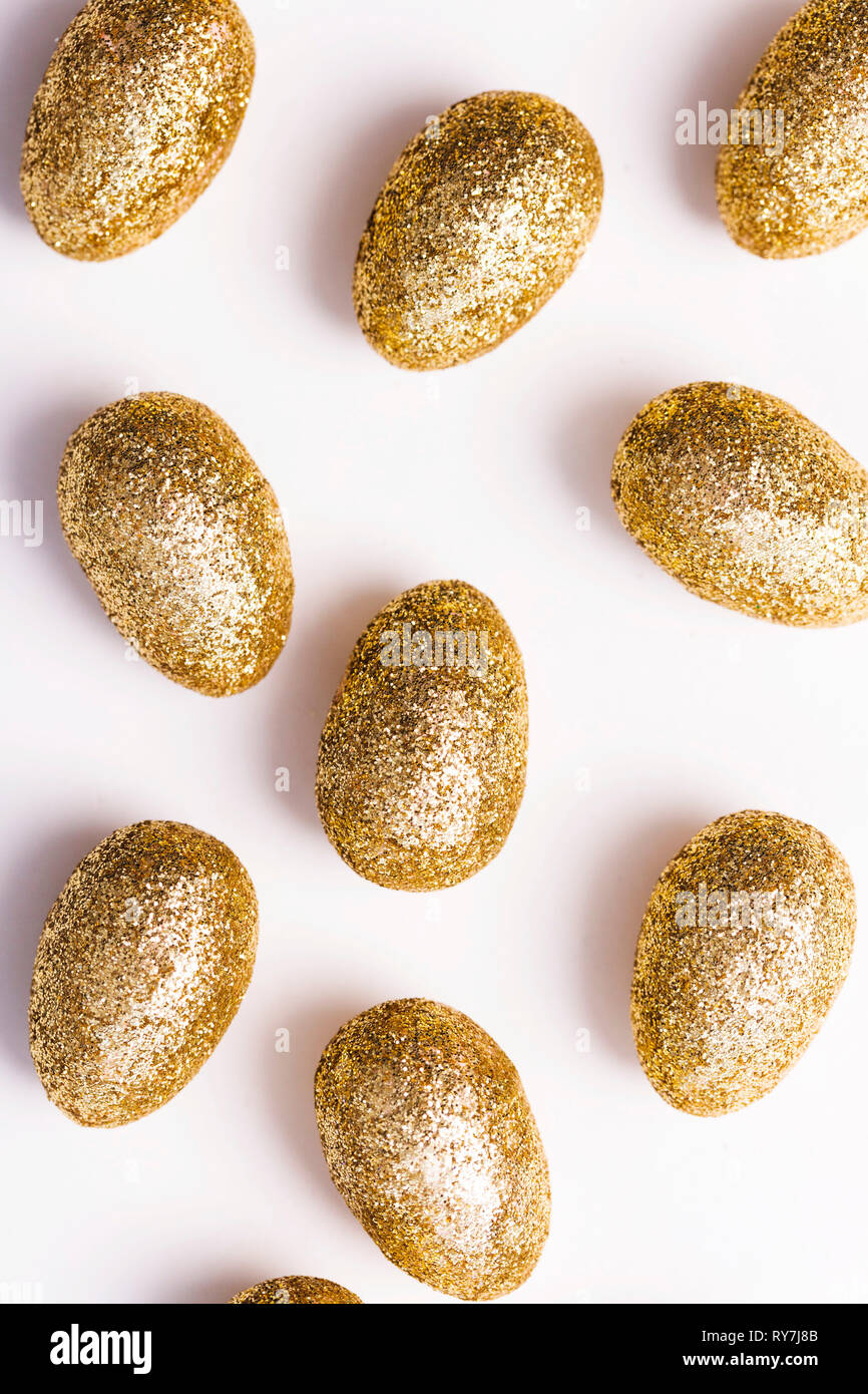 Oro glitter uova di pasqua su sfondo bianco Foto Stock