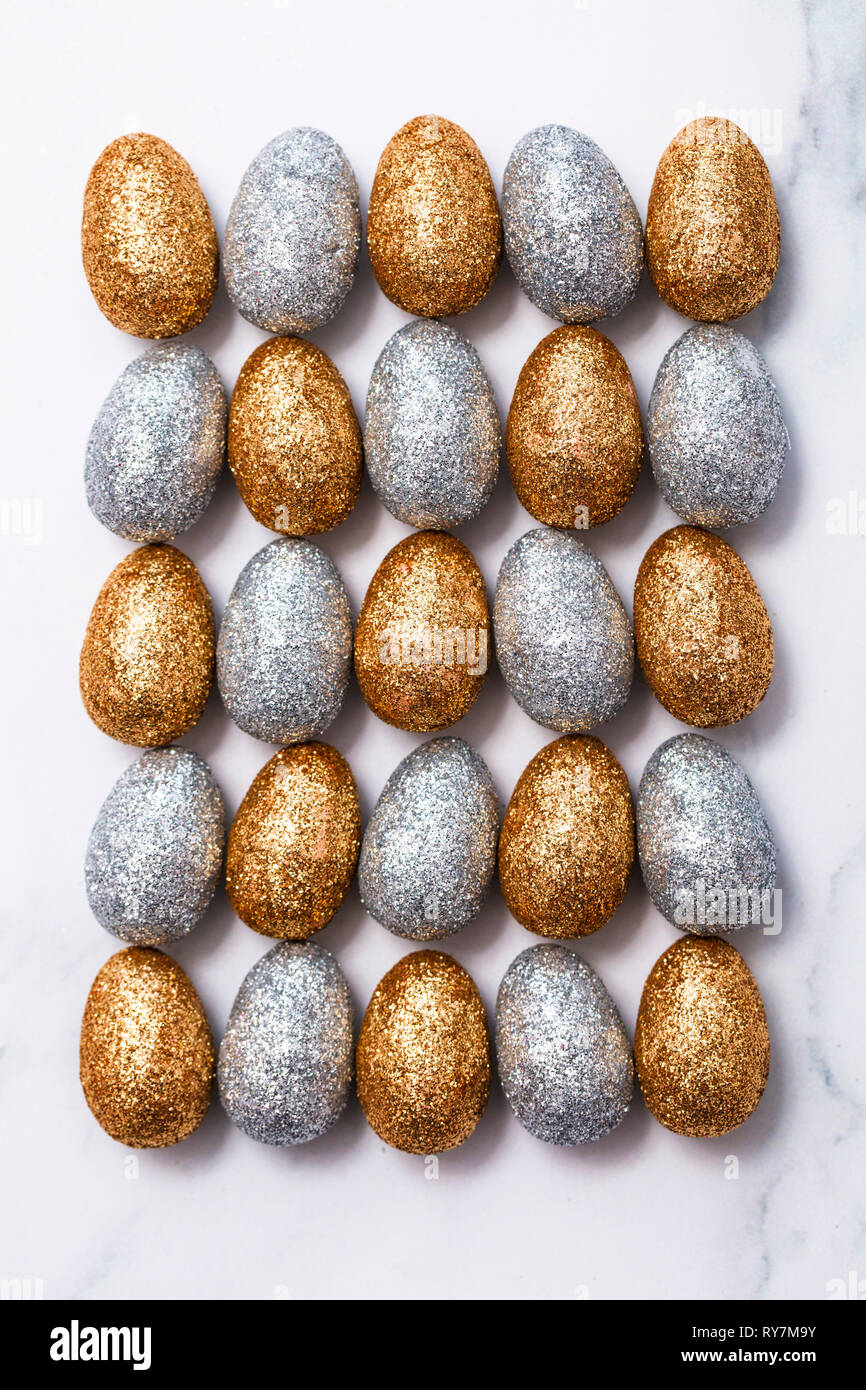 Oro e argento glitter uova di pasqua su un Sfondo marmo Foto Stock