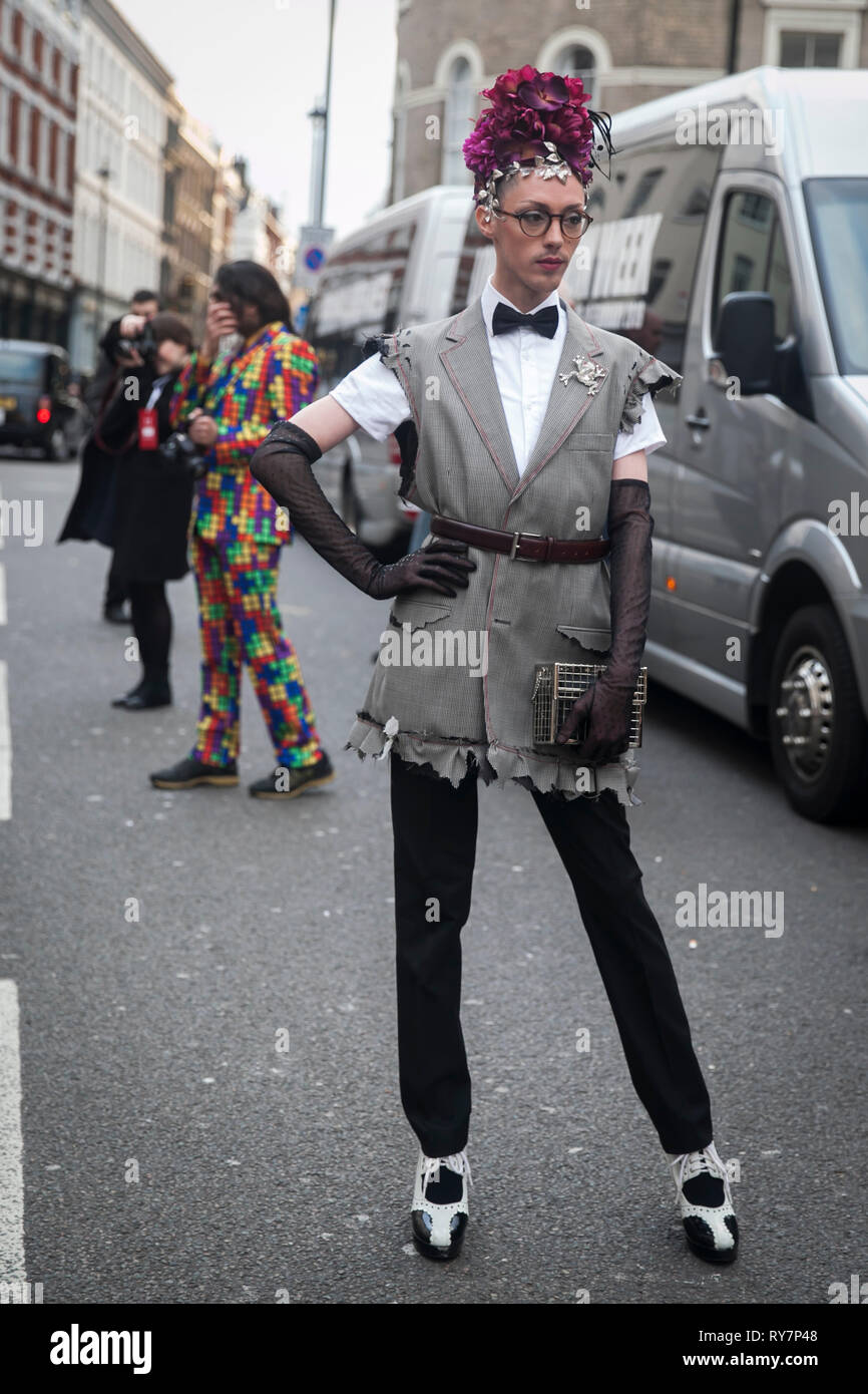 Londra - 17 febbraio 2019: guest è visto indossare un gingham Belted Dress, camicia bianca, papillon, lunghi guanti neri e sella oxford-ispirato scarpe outs Foto Stock