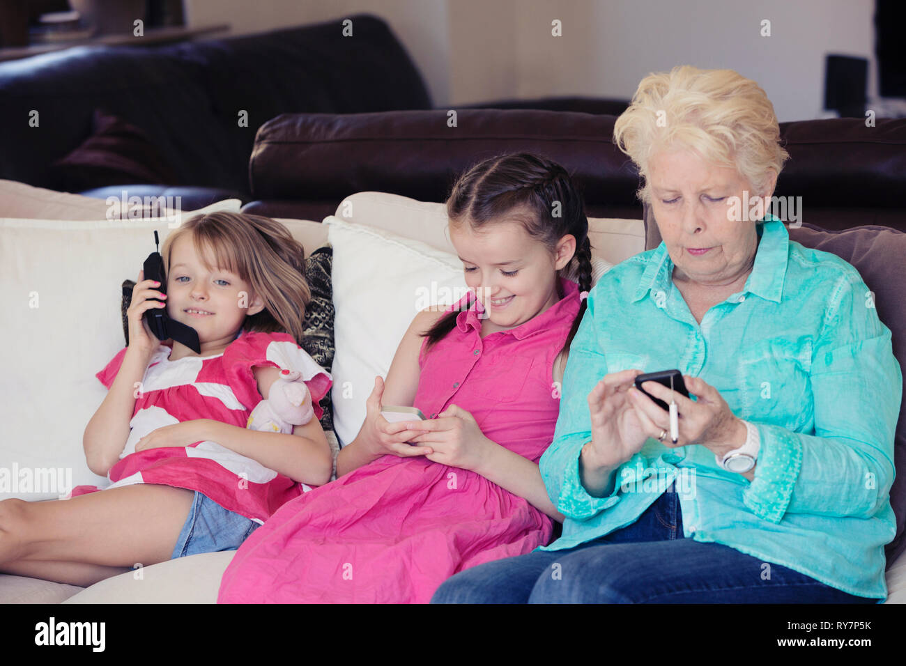Nonni e bambini che utilizzano i telefoni cellulari Foto Stock