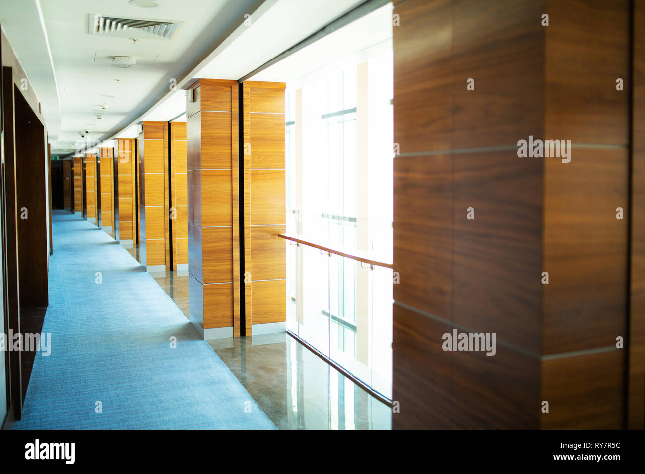 Hall con colonne di legno, moquette blu sul pavimento Foto Stock