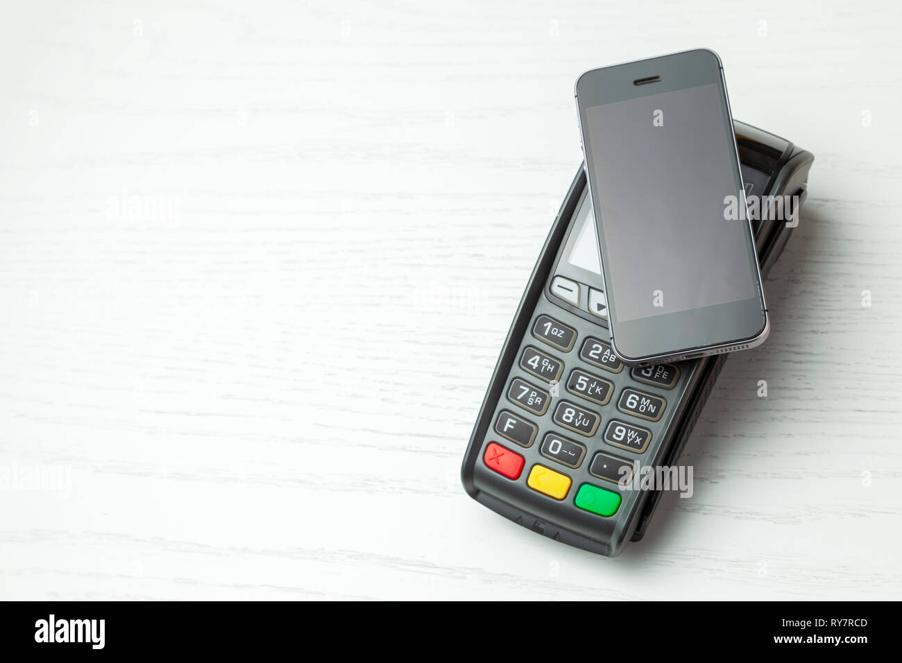 Terminale POS, macchina di pagamento con il cellulare su sfondo bianco. Il  pagamento senza contatto con la tecnologia NFC Foto stock - Alamy