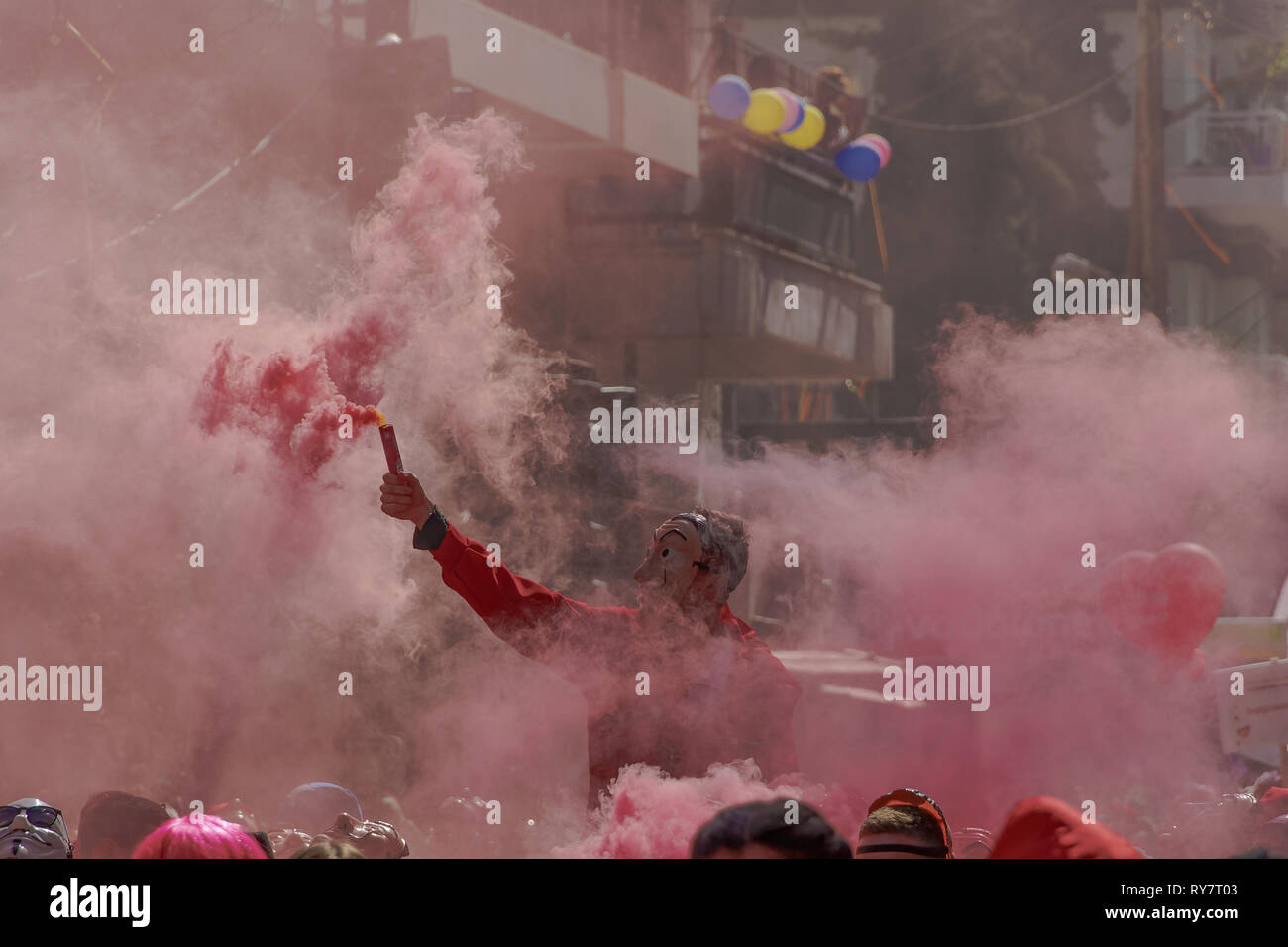 Casa de Papel costume sfilata di carnevale partecipante detiene il flare.  Salvador Dali felpa con cappuccio rosso costume tuta persona con denso fumo  accesa flare in Xanthi Foto stock - Alamy