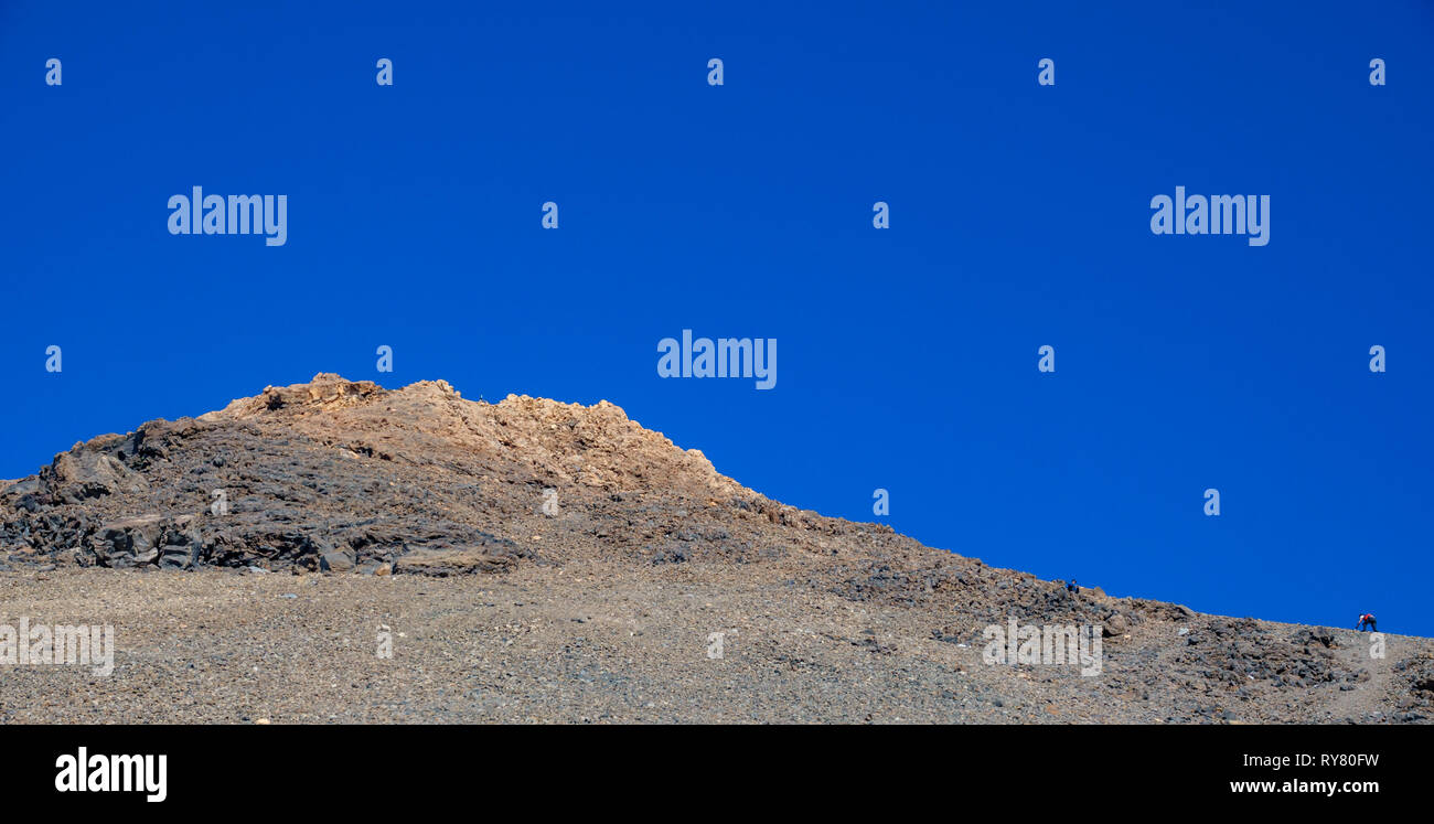 Runner difficile Arrampicata pendenza del vulcano Teide contro il cielo blu Foto Stock