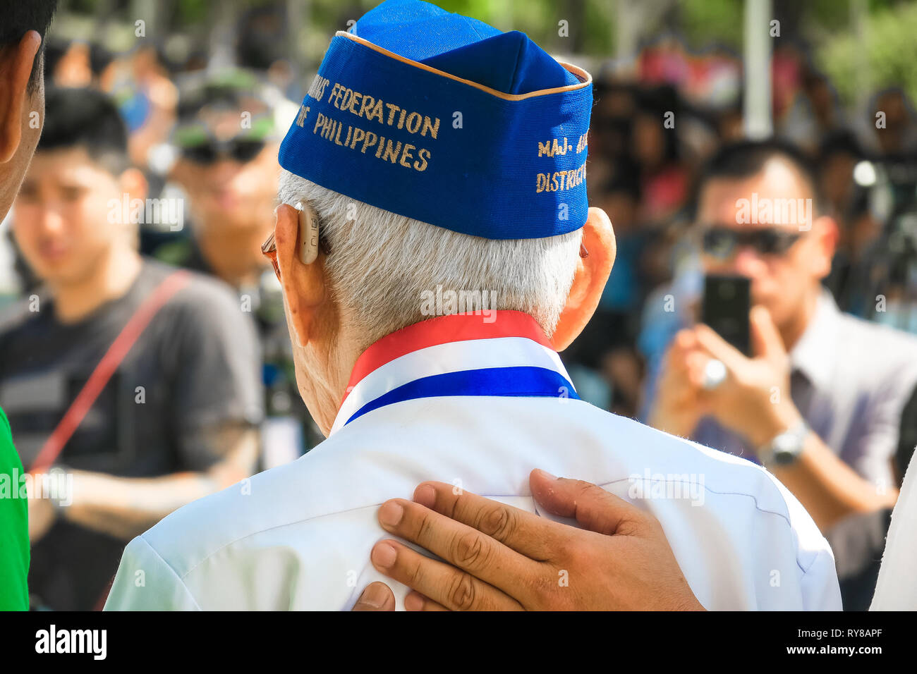 Il veterano della Seconda guerra mondiale grandi Alfredo Jimenea ottiene una pacca sulla spalla durante la 74Bataan Giorno Anniversario - Capas Santuario, Tarlac, Filippine Foto Stock