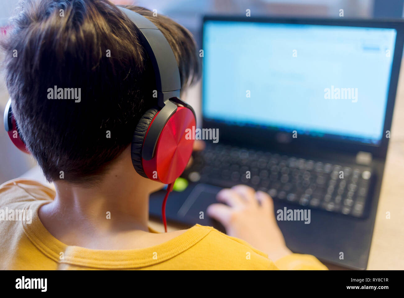 Ragazzo apprendimento utilizzando il computer portatile a casa Foto Stock