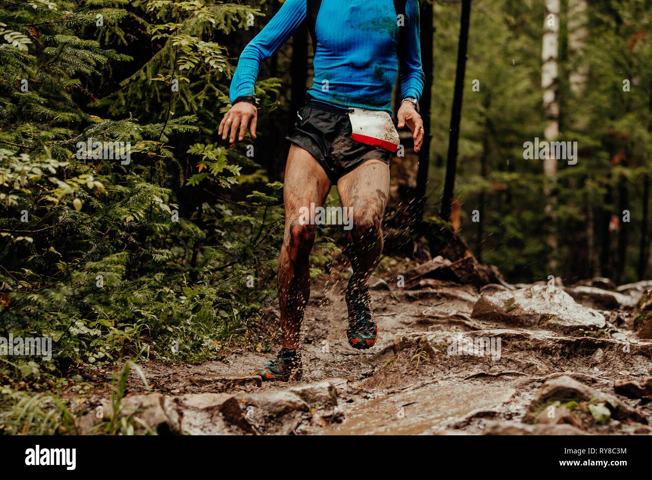 Sporco atleta runner acceso pozze di fango gli spruzzi di acqua Foto stock  - Alamy
