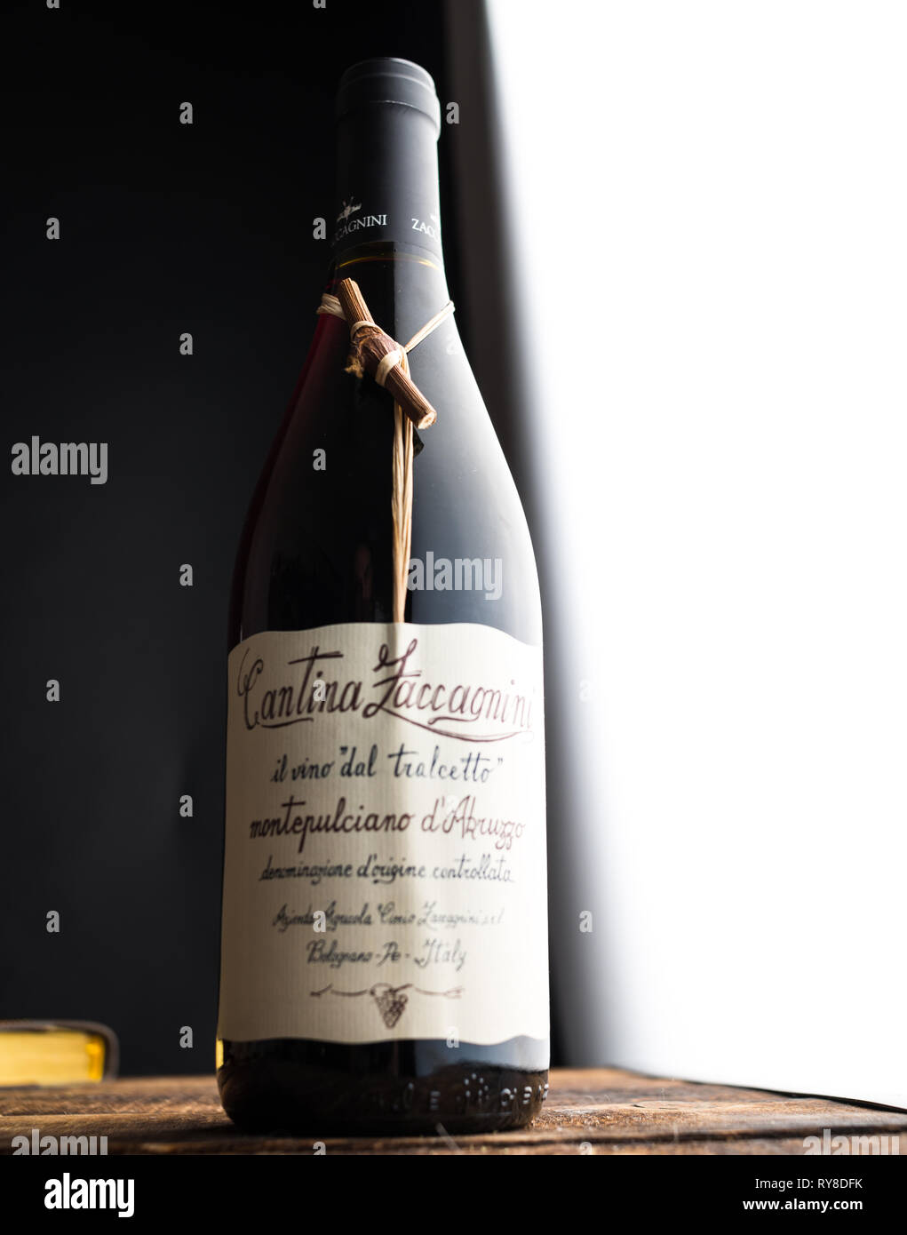 Bicchiere di vino e una bottiglia in legno scuro dello sfondo. Foto Stock