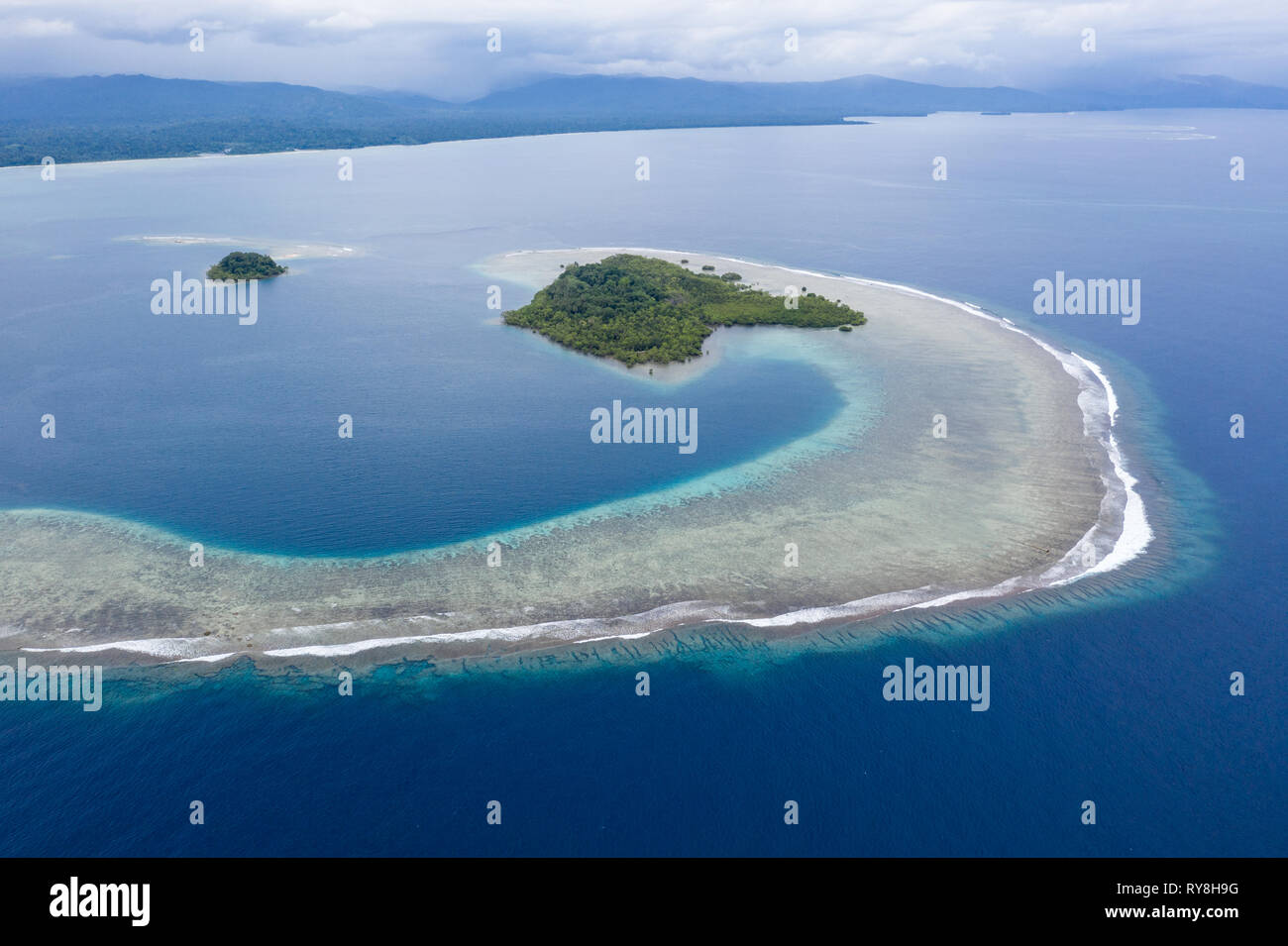 Una fantastica isola tropicale è circondato dalla barriera corallina in Papua Nuova Guinea. Questa remota zona è parte del triangolo di corallo grazie alla sua biodiversità marina. Foto Stock
