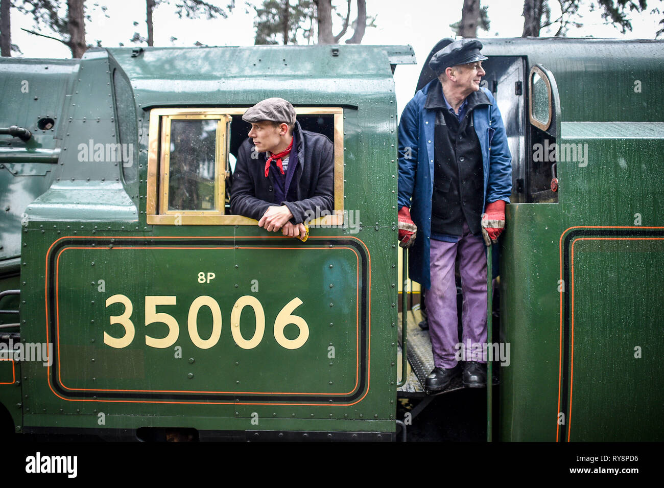 Autista Ben Evason, sinistra e pulitore Stephen Parker, destra a bordo di SR ???Marina Mercantile??? Pacific n. 35006 ???Peninsular & Oriental SN Co??? Come arriva a Cheltenham racecourse su un patrimonio speciale di vapore il servizio di treno espresso da Gloucestershire Warwickshire Steam Railway Station a Toddington, dove i frequentatori di gara sono trattati per un periodo di viaggio ferroviario il primo giorno del festival. Foto Stock