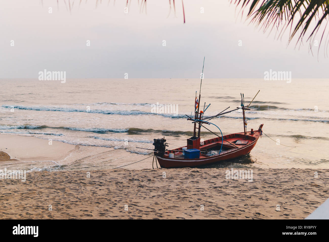 Tradizionale coda lunga la pesca in barca al tramonto con pescatore sulla costa di Hua Hin, Thailandia. Foto Stock