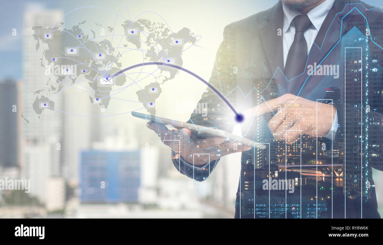 La doppia esposizione di imprenditore utilizzando tablet per inviare il messaggio di posta elettronica con il paesaggio urbano e grafico finanziario su edificio sfocata sullo sfondo,Business negoziazione c Foto Stock