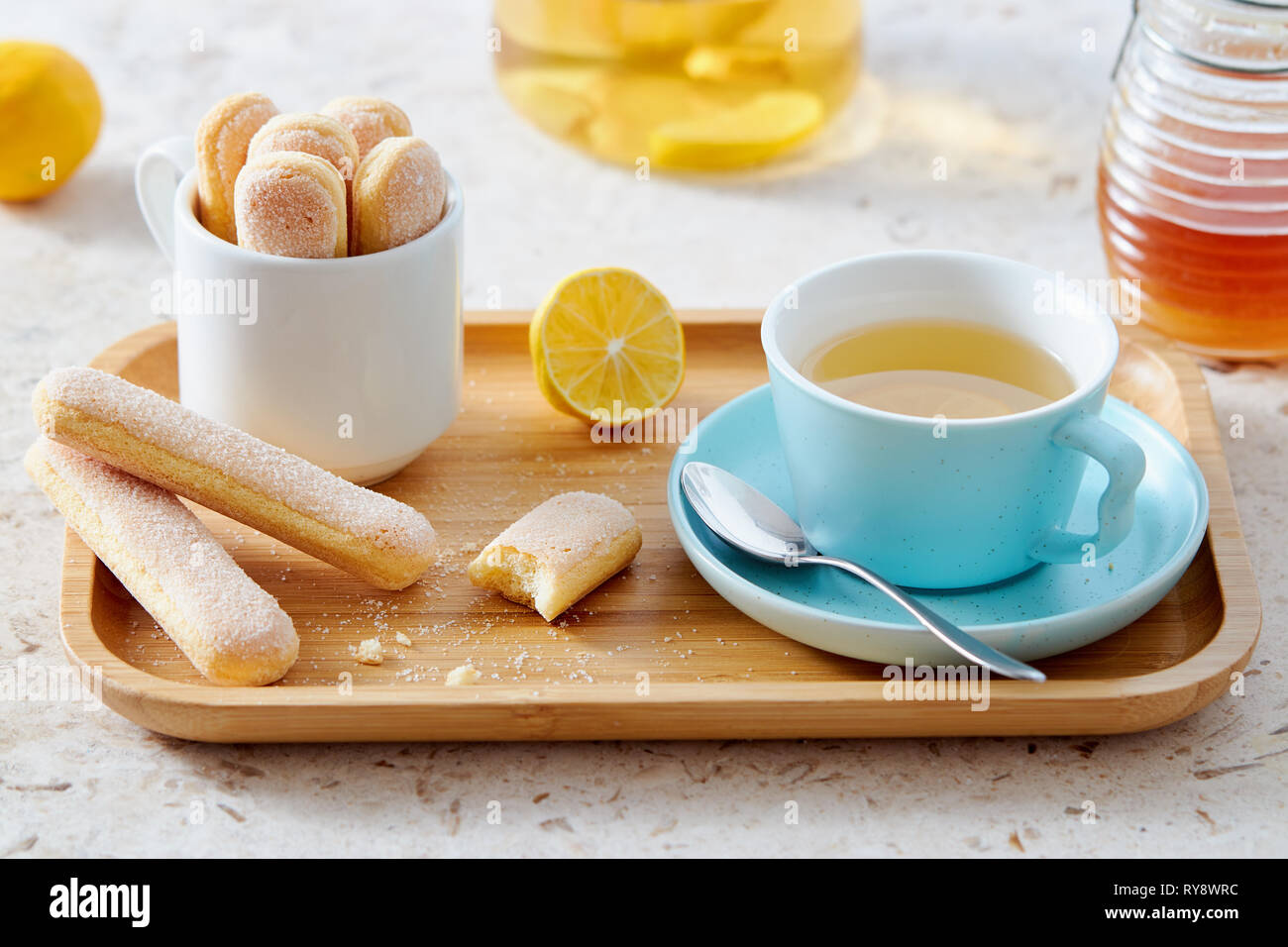 Dito di spugna biscotti serviti con una tazza di tè sul vassoio in legno Foto Stock