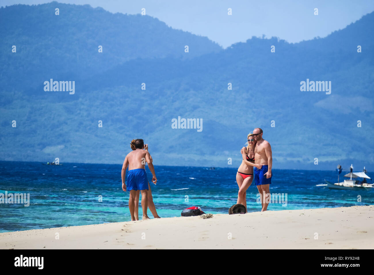 Turistico europeo prendendo le coppie di foto delle vacanze sulla spiaggia di sabbia bianca - Isola di Linapacan, Palawan - Filippine Foto Stock
