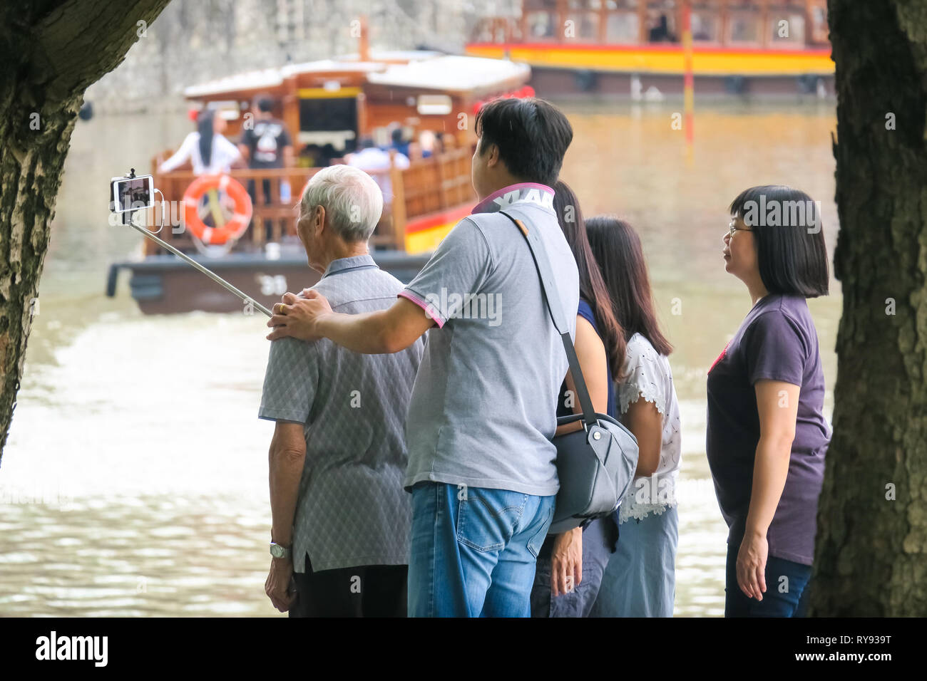 Cinese famiglia turistica prendendo selfie stick le foto con i nonni - Clarke Quay, Singapore Foto Stock