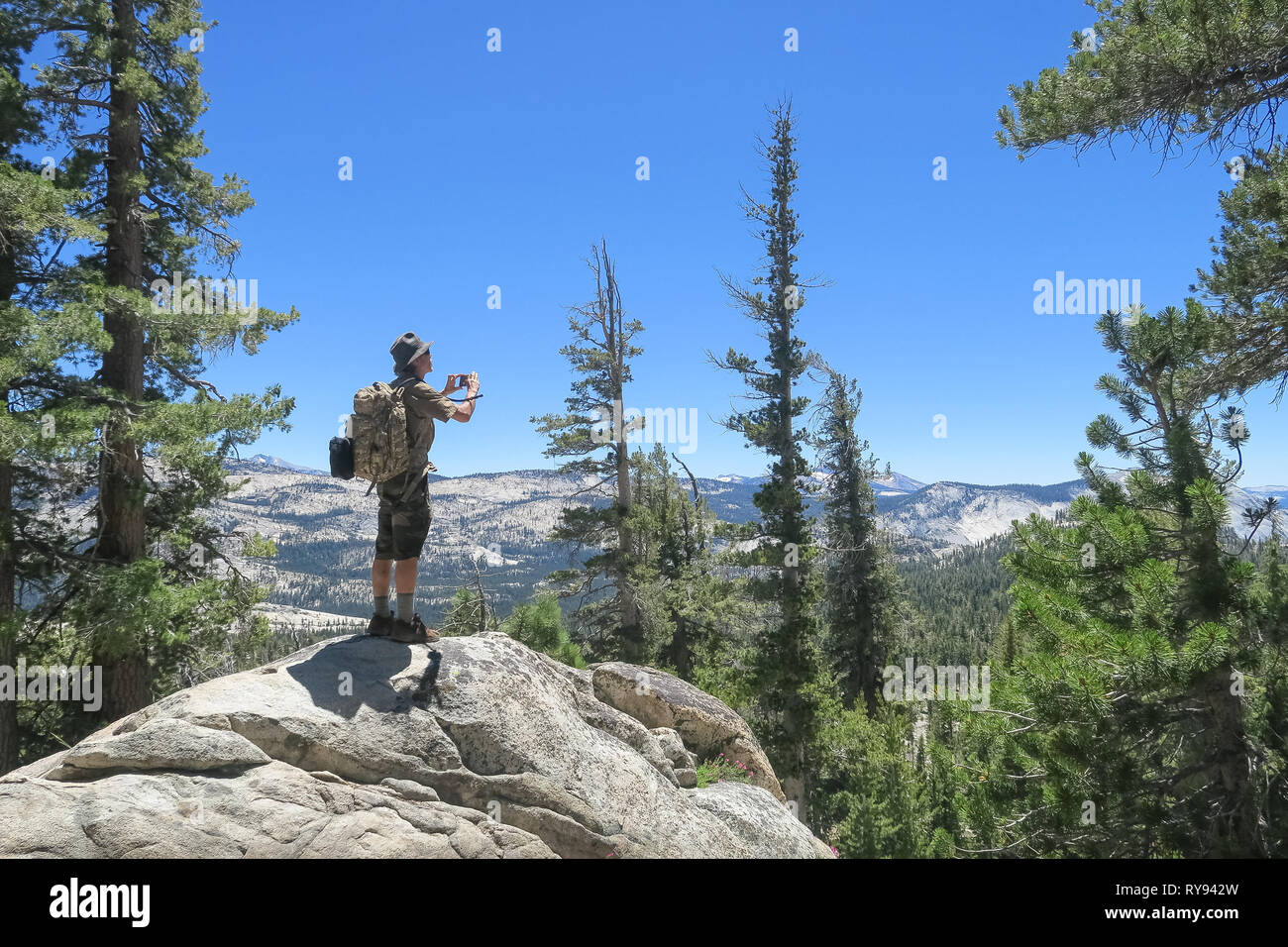 Deserto escursionista prendendo le foto dello smartphone con zaino camouflage - Parco Nazionale di Yosemite in California Foto Stock