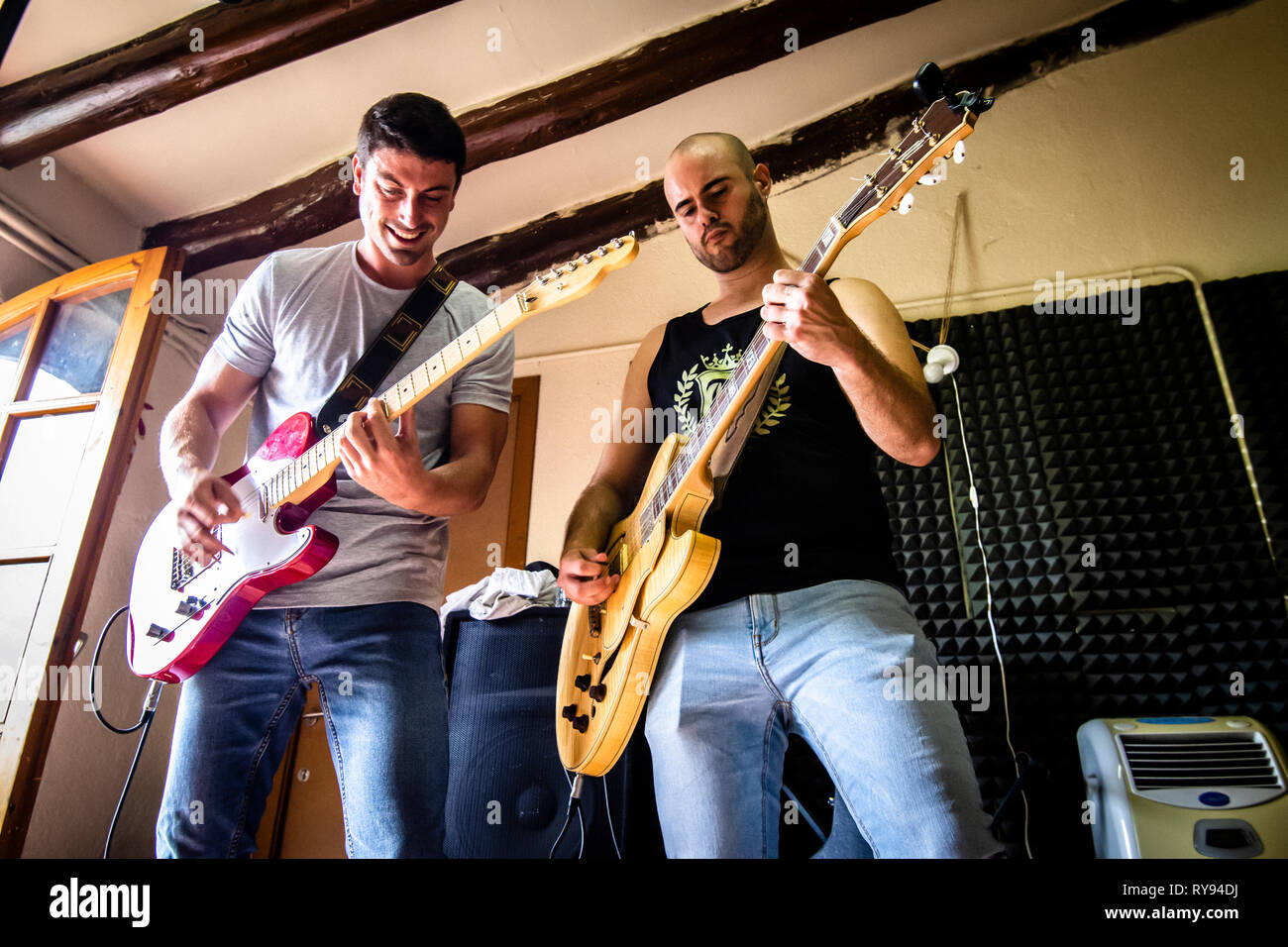 Basso angolo vista dei chitarristi maschio riproduzione di chitarre in studio Foto Stock