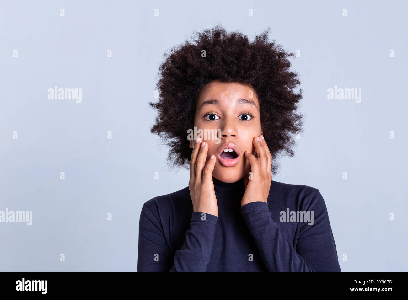Pretty African American boy la riproduzione sulla fotocamera e toccando il suo volto Foto Stock