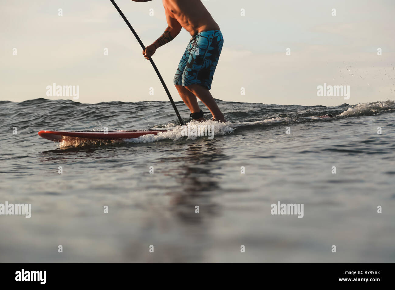 Fondo del raccolto dei maschi di navigare tra acqua di mare di Bali, Indonesia Foto Stock