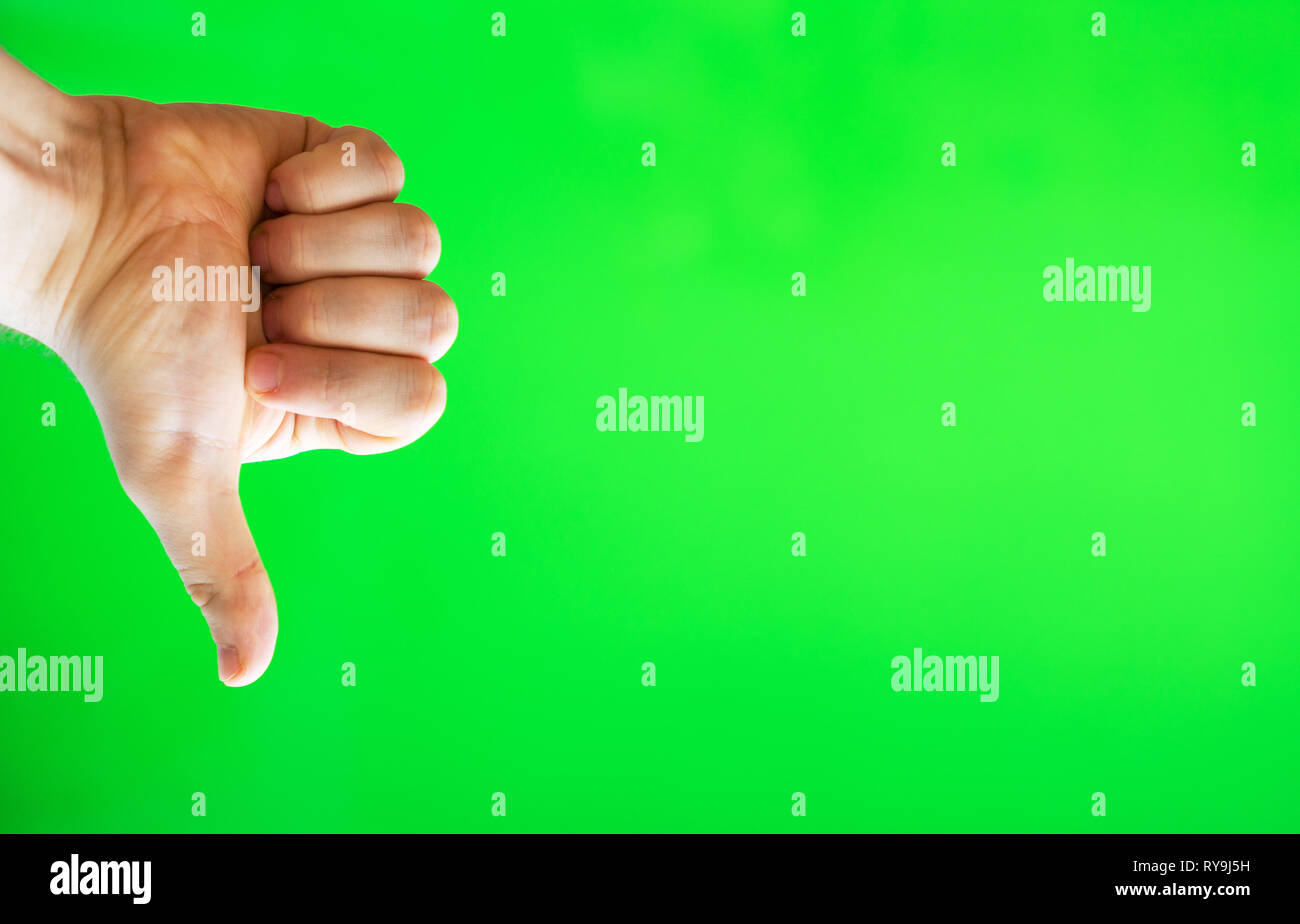 Mano maschio che mostra il pollice verso il basso. Il chroma key. Posto per la vostra pubblicità. Foto Stock
