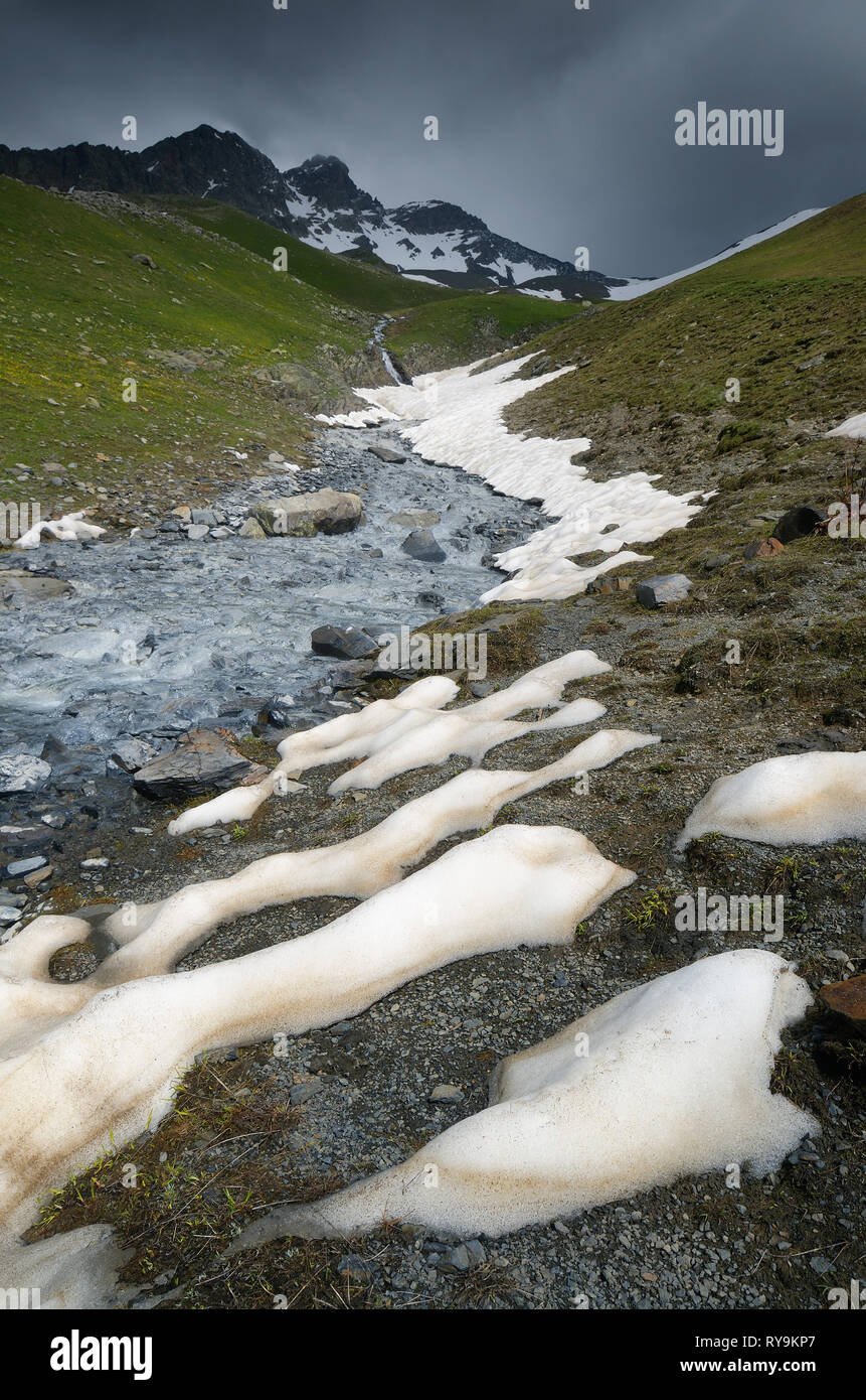Freddo intenso paesaggio di montagna con il fiume di montagna. La fusione di neve in montagna. Svaneti, Georgia, nel Caucaso Foto Stock