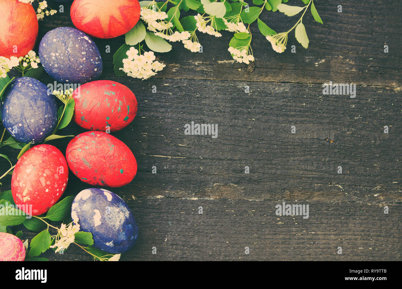 Colorate le uova di Pasqua al buio su un sfondo di legno Foto Stock