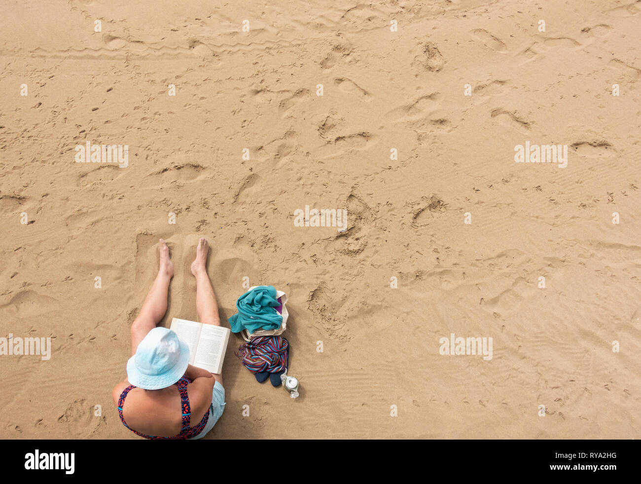 Donna libro di lettura sulla spiaggia. Foto Stock