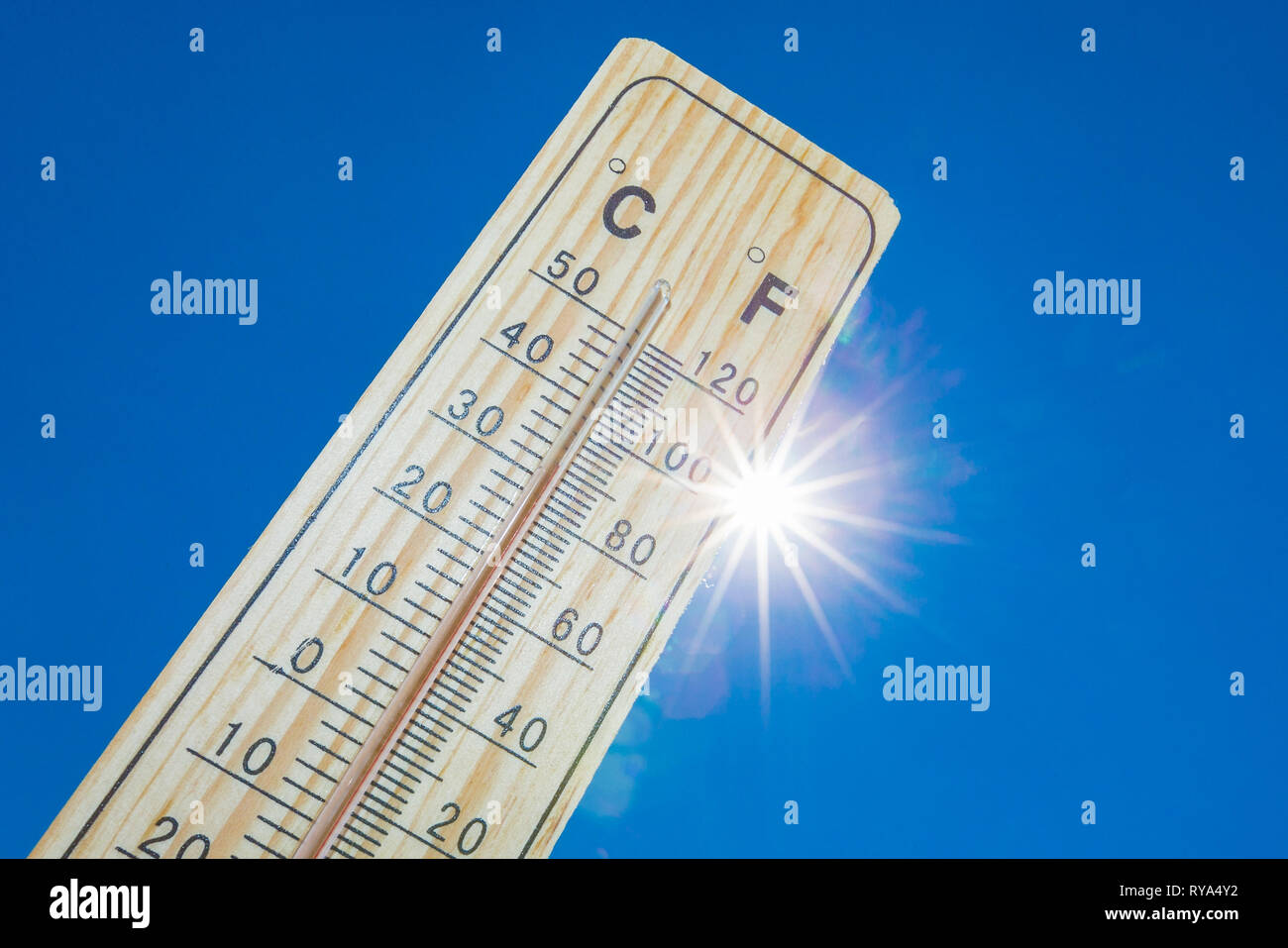Ein termometro vor der gleissenden Sonne am blauen Himmel Foto Stock