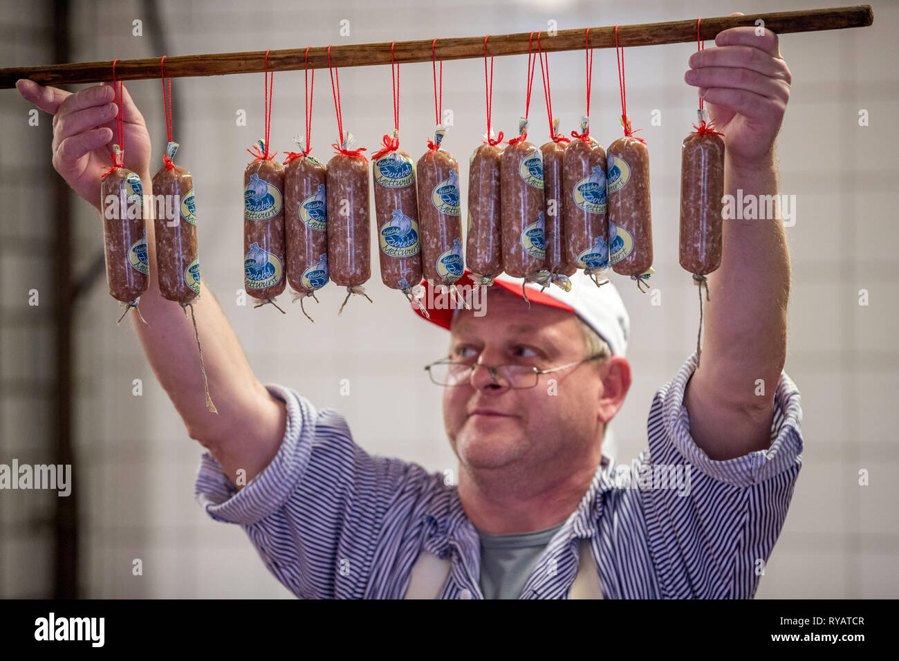 Ludwigslust, Germania. Xx Febbraio 2019. Butcher Hannes Schumacher detiene un bastone di cipolla salsiccia nella produzione di insaccati del Ockens macelleria. Credito: Jens Büttner/dpa-Zentralbild/ZB/dpa/Alamy Live News Foto Stock