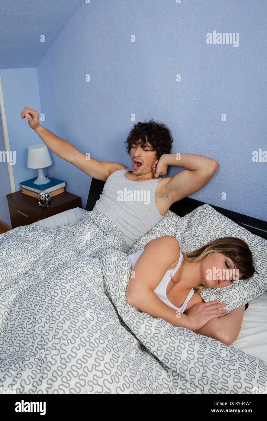 Uomo di svegliarvi mentre la moglie dorme Foto Stock