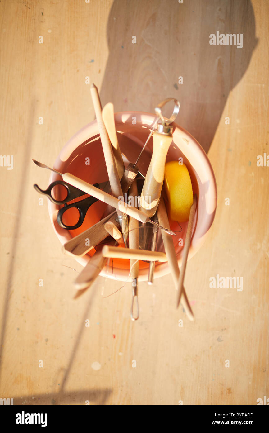 Vista superiore in legno strumenti in ceramica nel recipiente di ceramica, rustico caldo sfondo arte Foto Stock