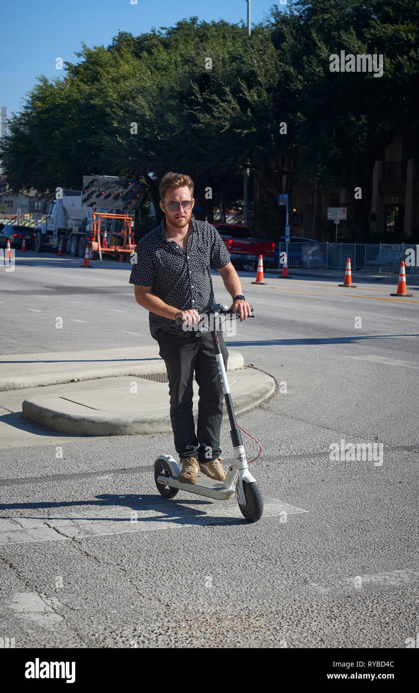 Un uomo che cavalca un elettrico e scooter a noleggio South Congress Avenue, Austin, Texas Foto Stock