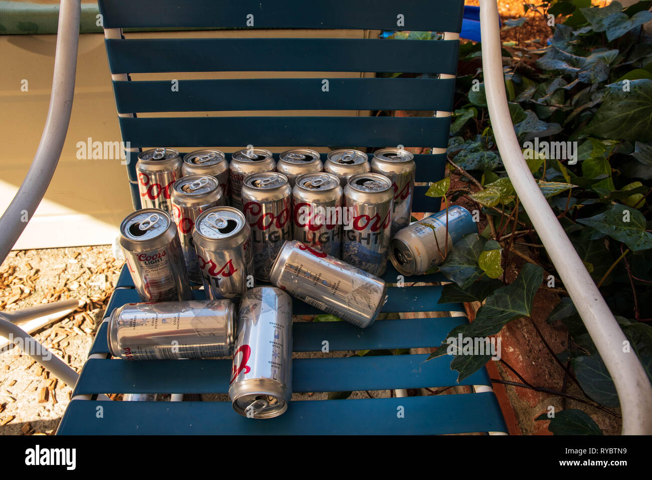 Fairfax, California - 10 Febbraio 2019: Vuoto Coors Light di lattine di birra sul outdoor lounge chair dopo barbecue party Foto Stock