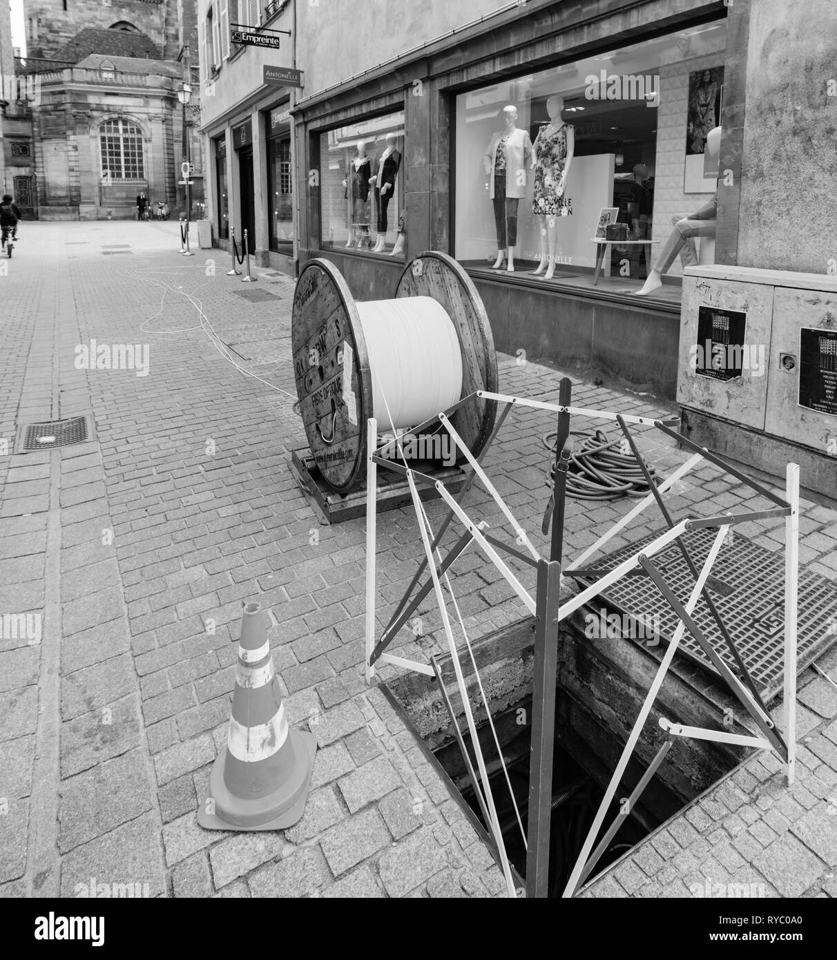 Strasburgo, Francia - Mar 12, 2018: in fibra ottica l'installazione nel centro città zona pedonale con grande rullo di acciaio cavi dati sito di costruzione delle infrastrutture delle reti pubbliche Foto Stock