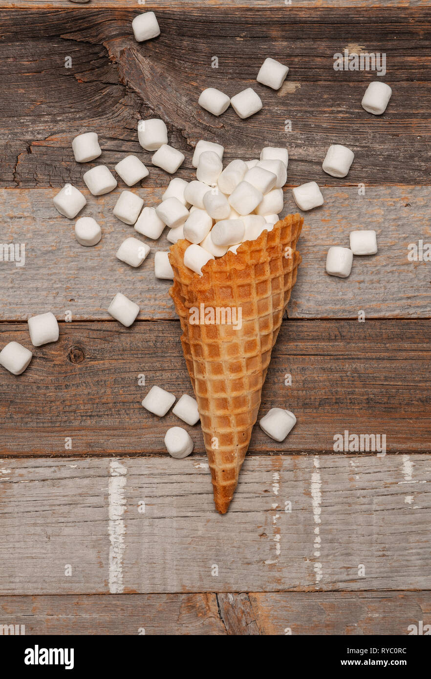 Marshmallow nel cono gelato sul tavolo di legno Foto Stock