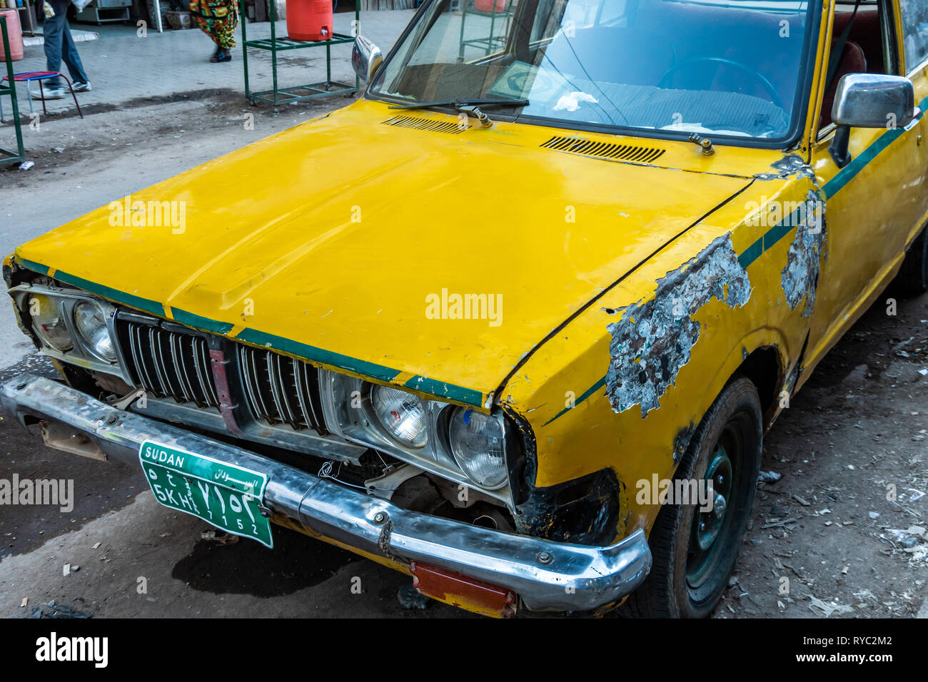 Il governo di Khartoum, Sudan, Febbraio 5, 2019: vecchia auto gialla con corano dietro il parabrezza in una strada laterale del capitale Foto Stock