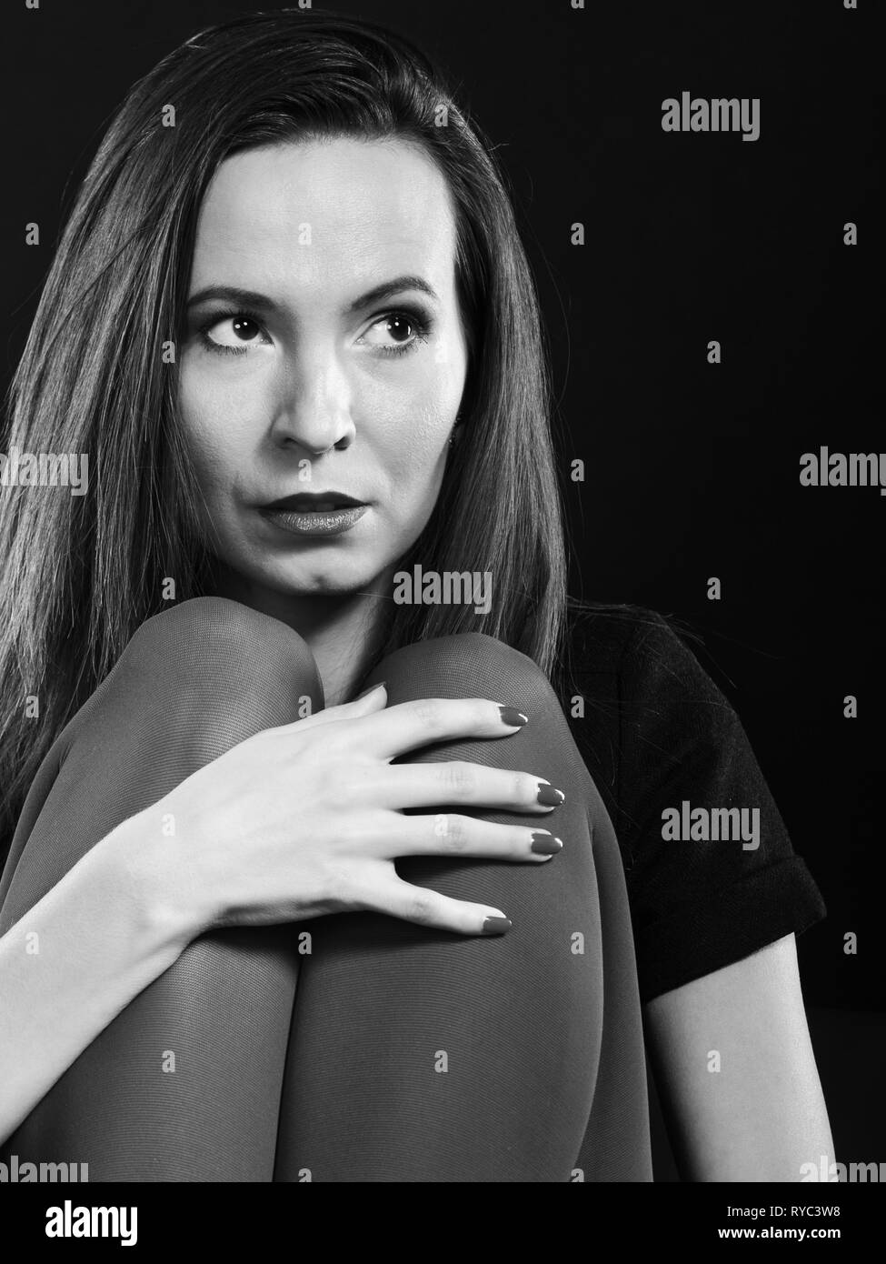 Triste donna colori vividi collant seduto sul divano bianco nero photo Foto Stock